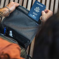 a person holding a bag with a passport in it