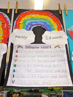 a bulletin board with rainbows and clouds on it in front of a classroom wall