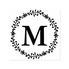 the letter m is surrounded by a wreath