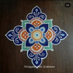 an intricate design on the floor is painted with blue, orange and green colors to make it look like a flower