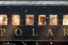 a train car with people looking out the windows on a snowy day at polar station