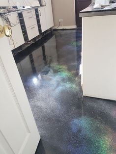 a kitchen floor that is shiny and has some colored flakes on the ground next to it