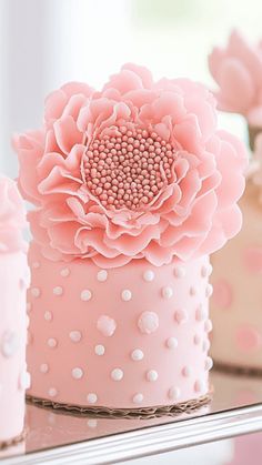 pink and white cakes decorated with flowers on a table