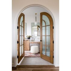 an arched doorway leading to a bathroom with a sink and mirror