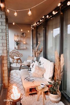 a living room filled with furniture and lots of lights hanging from the ceiling above it