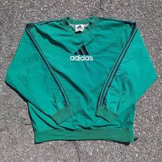 Staying true to my wife's era is this, 90s style fit that all the coolest of kids rocked! Cop this gorgeous vintage Adidas pullover windbreaker sporting the black racer stripe sleeve half-side zip sized as a large in the color green. Please, before my wife decides to keep it. Haha. Urban Crew Neck Track Jacket For Sports, Sportswear Windbreaker With Three Stripes, Long Sleeve Windbreaker With Three Stripes, Sporty Crew Neck Track Jacket For Sports Events, Vintage Long Sleeve Track Jacket For Sports, Retro Track Jacket With Three Stripes, Three Stripes Windbreaker For Streetwear, 90s Style Sports Outerwear With Crew Neck, Vintage Crew Neck Track Jacket For Sports