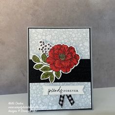 a close up of a card with a red flower on the front and black background