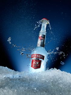 a bottle of smirnoff is splashing out of the ice