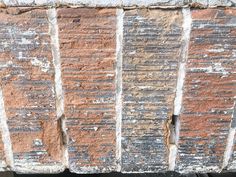 an old brick wall that has been stripped and chipped with some paint on it