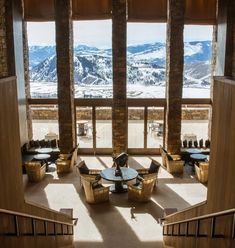 an open lobby with tables and chairs overlooking mountains