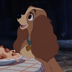 lady and the tramp sitting at a table eating spaghetti