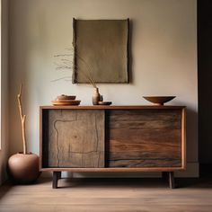 a wooden cabinet sitting next to a window with a painting on the wall behind it