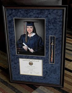 a framed photo of a woman in her graduation cap and gown, holding a diploma