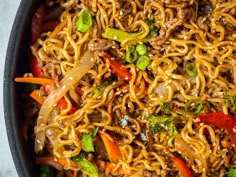 a pan filled with noodles and vegetables on top of a table