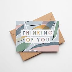 two greeting cards with the words thinking of you printed on them, sitting next to each other