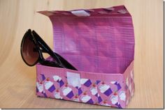 a pair of sunglasses sitting inside of a purple bag on top of a wooden table