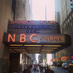 people are walking down the street under a marquee for nbc's rainbow room