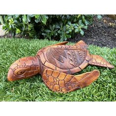 a carved turtle laying in the grass