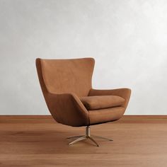 a brown chair sitting on top of a hard wood floor next to a white wall