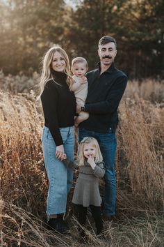 a family posing for a photo in the tall grass