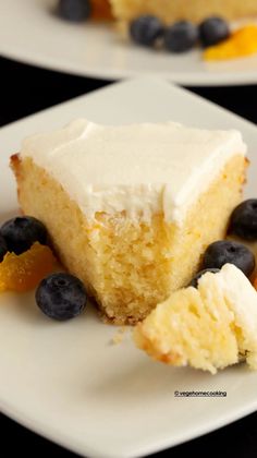 two slices of cake with white frosting and blueberries