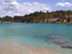 the water is crystal blue and clear with some trees in the backgrouds