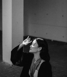 a woman sitting on the ground holding her hand up