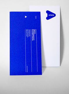 two blue and white business cards sitting next to each other