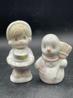 two little white figurines sitting next to each other