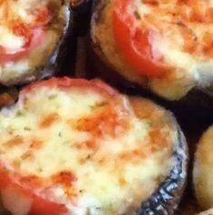 several baked food items sitting on top of each other with cheese and tomato toppings