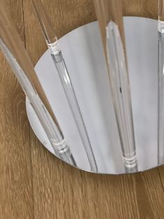 four glass straws in a metal holder on a wooden table