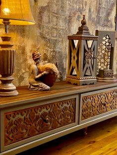 an ornately decorated sideboard with lamps and other decorative items on the top shelf