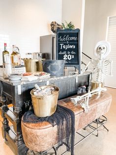 a skeleton statue sitting on top of a wooden bench next to a chalkboard sign