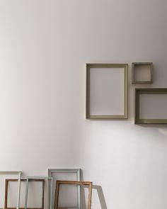 four frames are arranged on the wall near each other in different shapes and sizes, along with one another