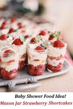 strawberry shortcakes with whipped cream and fresh strawberries in jars on a tray