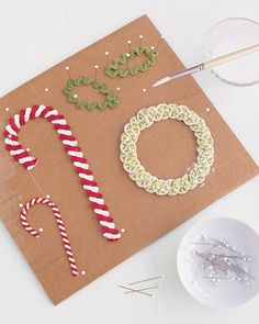 some candy canes and other holiday decorations on a piece of brown paper next to scissors