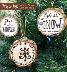 three wood slice ornaments hanging from a christmas tree with the words let it snow written on them