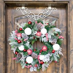 a christmas wreath hanging on a wooden door