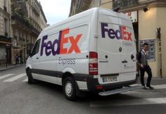 a fedex van parked on the side of the road