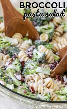 broccoli pasta salad in a glass bowl with wooden spoons