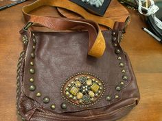 Large fantastic bag . Gorgeous pebble chocolate brown supple cowhide leather with chestnut brown 1.5 in wide strap . Stones are real tiger eye and river stone jasper accented with brass nails . Very unique bag . Bag is large . 12 x 11 x 3 in . Strap is adjustable 48 in t total so could be used for crossbody or adjusted to shoulder bag . Thinning out my collection . Never used . Just a fantastic whimsical but boho bag . Sold as is . Never used Vintage Leather Bags With Hardware, Vintage Leather Bags With Hardware Details, Brown Bags With Hardware For Daily Use, Brown Crossbody Shoulder Bag With Hardware, Brown Crossbody Bag With Hardware Details, Brown Leather Bags With Hardware, Chestnut Brown, Unique Bags, Pocket Book