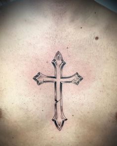 a man's chest with a cross tattoo design on it, in black ink