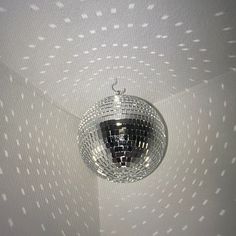 a disco ball hanging from the ceiling in a room with white walls and dots on it