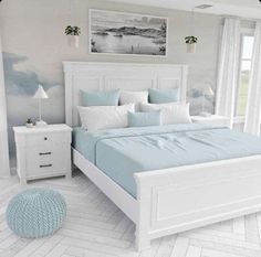 a white bed with blue sheets and pillows