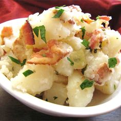 a white bowl filled with potato salad on top of a table