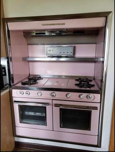 a pink stove top oven sitting inside of a kitchen