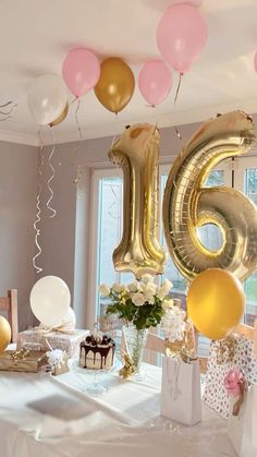 a table topped with balloons and cake next to a large number six balloon in the air