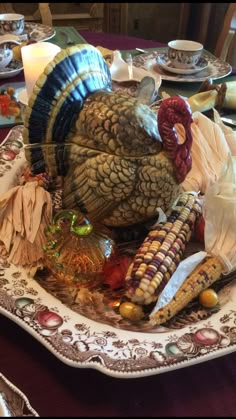 a turkey sitting on top of a plate with corn and other food items around it