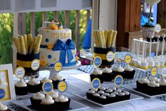 a table topped with cakes and cupcakes covered in frosting