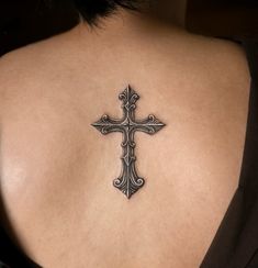 a woman with a cross tattoo on her back